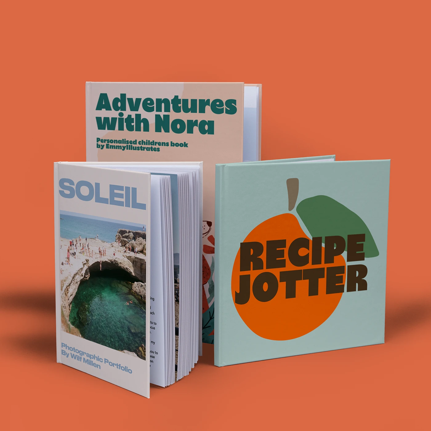 Three hardback books of varying sizes with different colourful designs including a recipe book, children's story book, and a photography portfolio.
