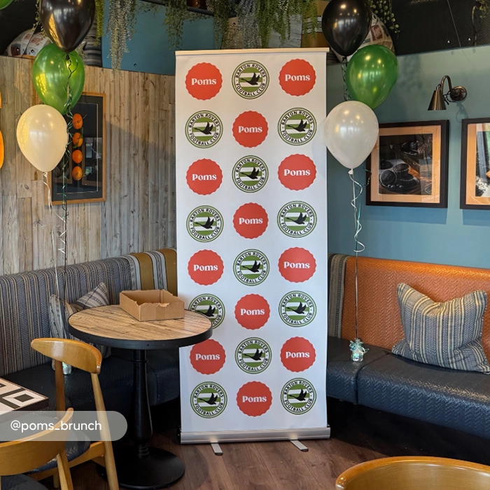 Cafe interior featuring a branded step-and-repeat standard roller banner.