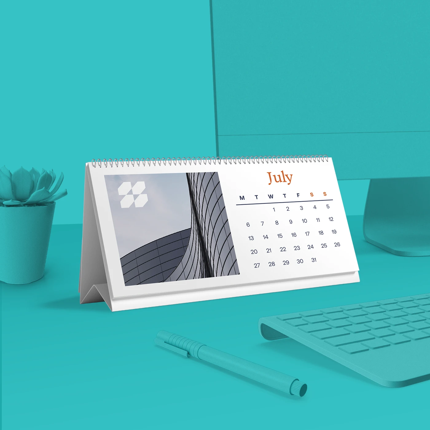Self-standing Calendar with a plain white and photography design, sitting on a blue desk with a computer screen, keyboard, pen, and houseplant.