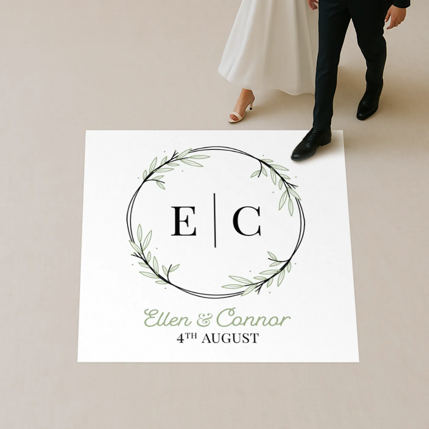 Floor decal with initials E | C and Ellen & Connor’s wedding date as a bride and groom walk by