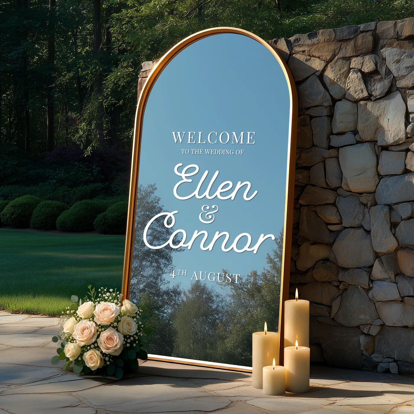 Arched gold framed mirror wedding sign for Ellen & Connor with roses and candles outdoors