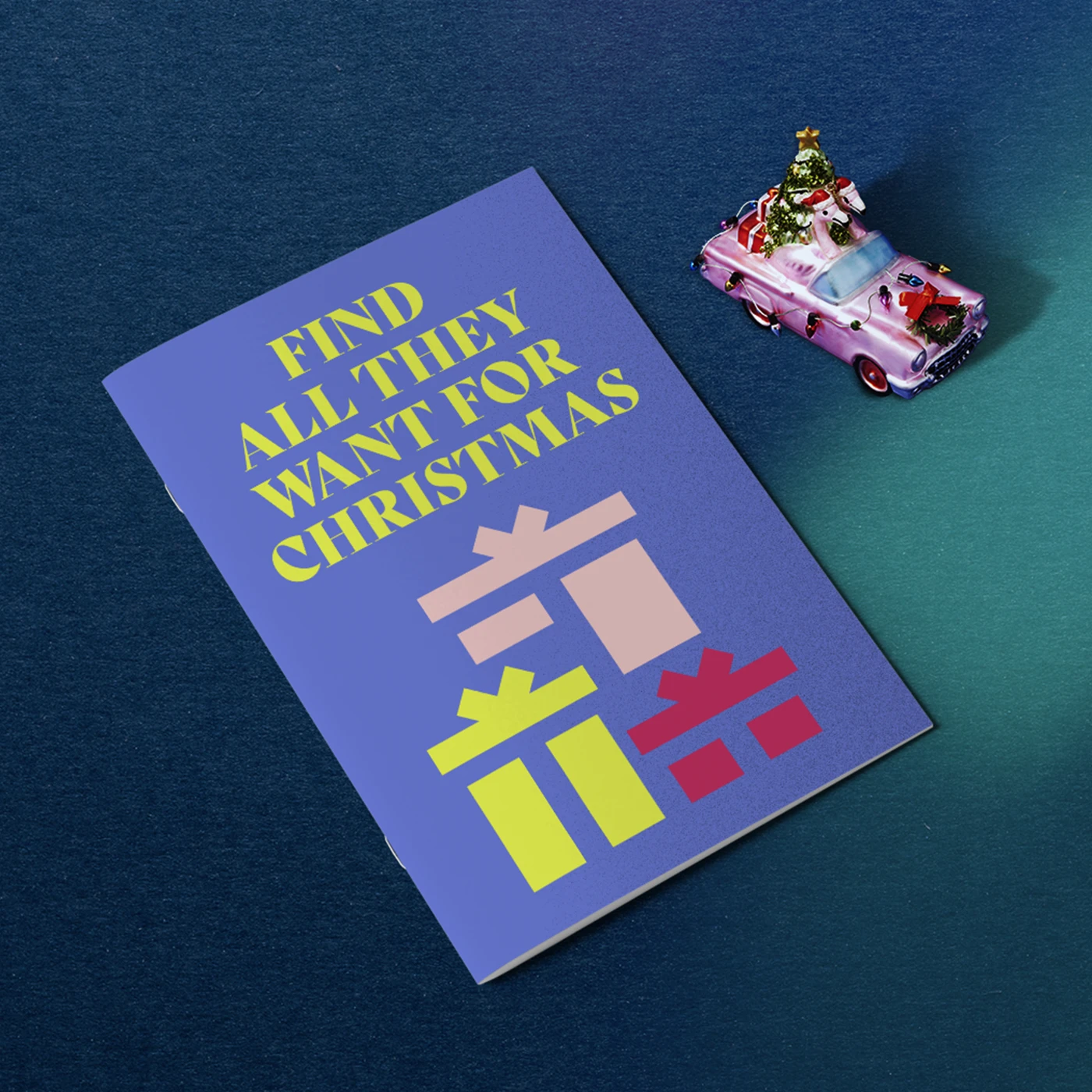 One saddle stitch booklet with a purple design and text reading 'find all they want for christmas', on a blue background with a pink christmas ornament.