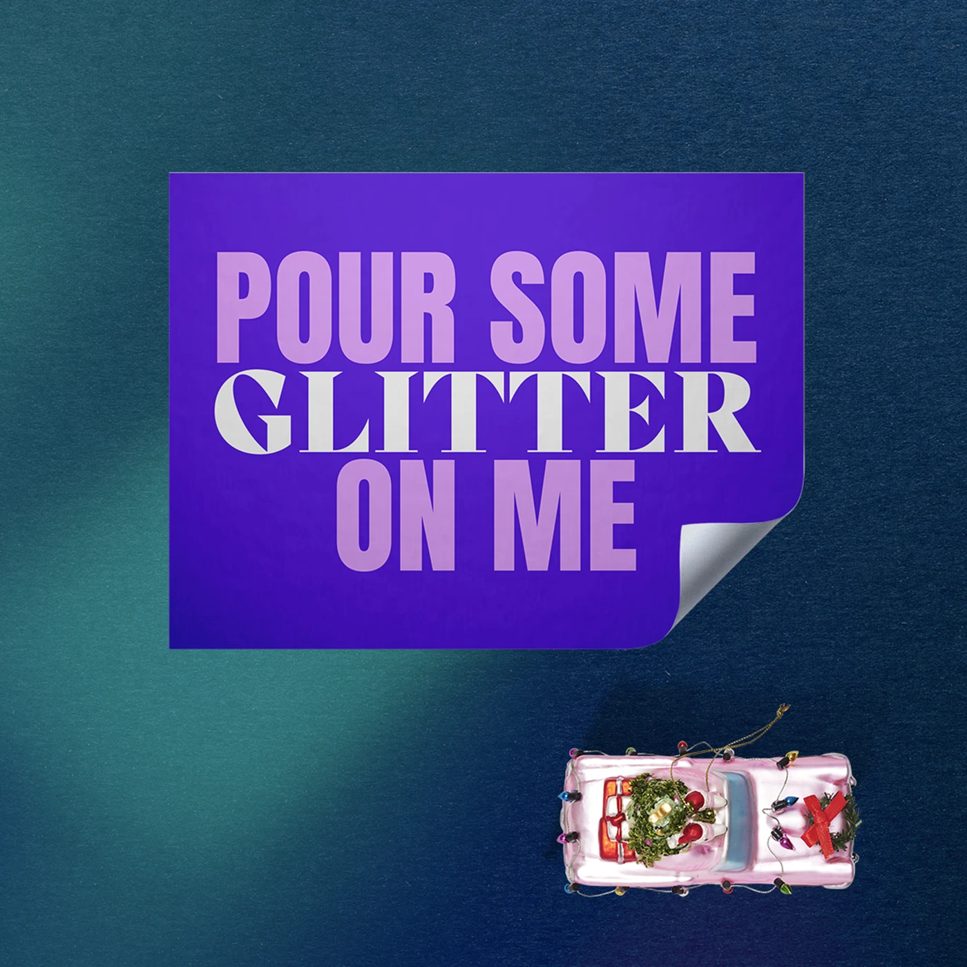 Rectangle self-adhesive vinyl Sticker with a purple design featuring bold pink text reading 'pour some glitter on me', on a dark blue background beside a pink christmas ornament.