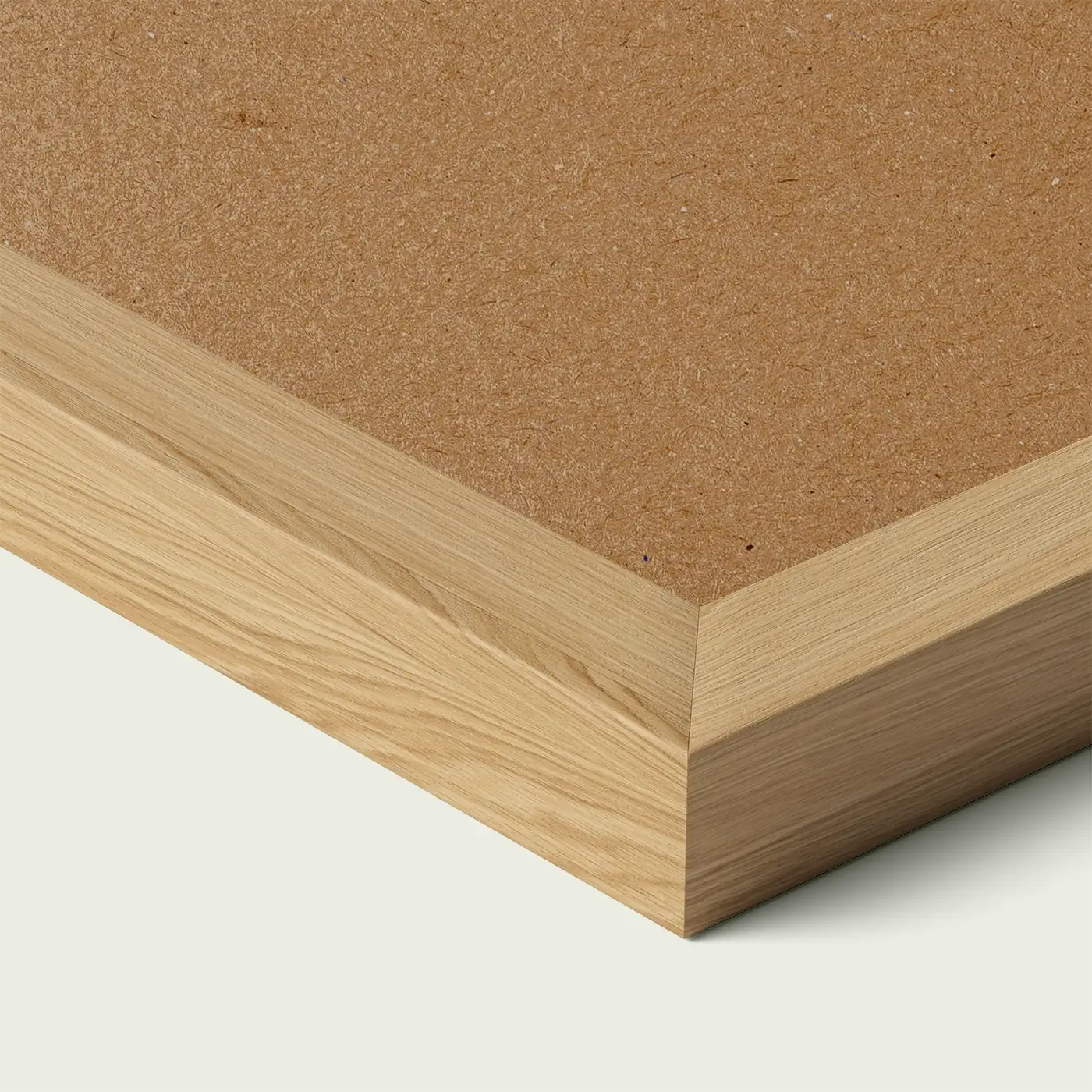 Close-up of an oak picture frame corner with smooth painted edge and wooden backing, shown against a light neutral background