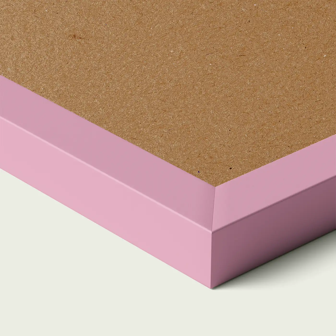 Close-up of a pink picture frame corner with smooth painted edge and wooden backing, shown against a light neutral background