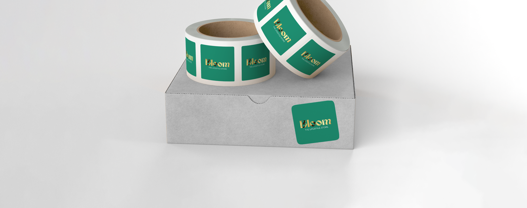 Gold foiled green Square Stickers, applied to a grey box, on a grey background.