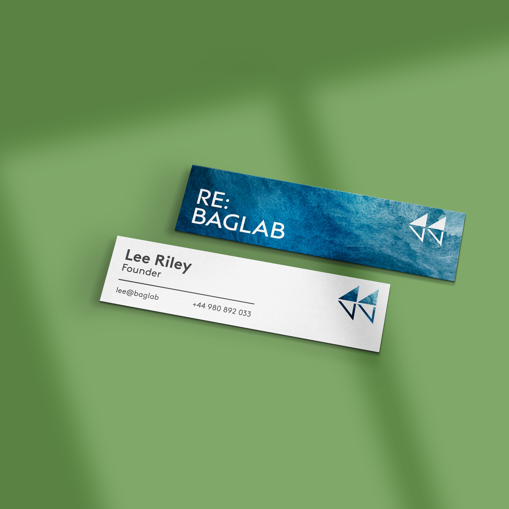 Two mini business cards on a green background, both with a blue and white design, one with a logo and one showing contact details.