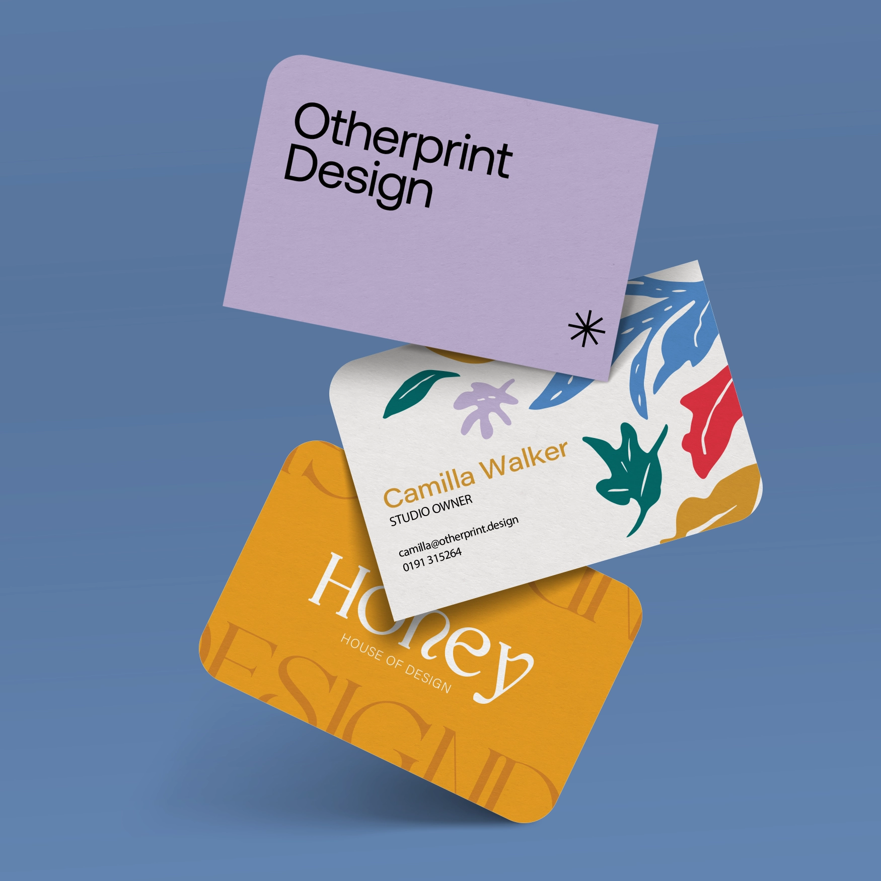 Three business cards on a blue background with colourful purple, white and yellow designs, one with four rounded corners, one with two rounded corners, and one with one rounded corner.