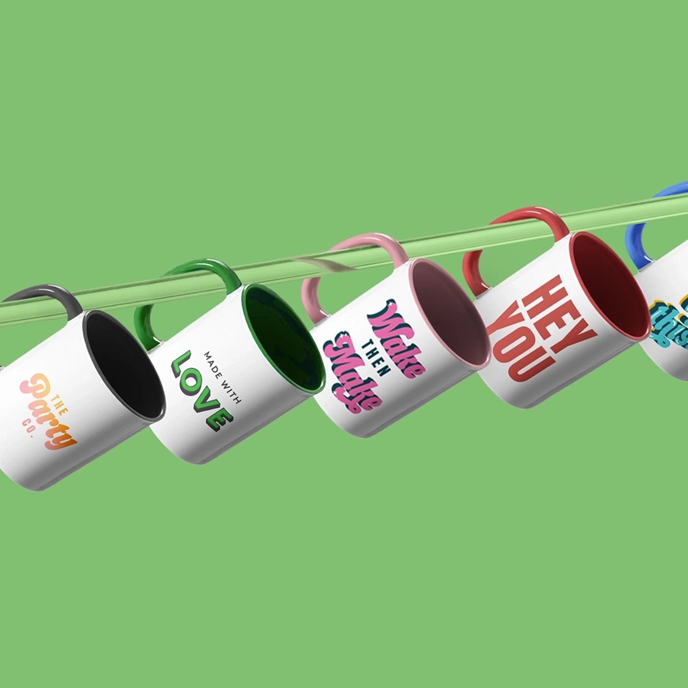 Six ceramic mugs hanging on a green rod, each with a different handle and interior color.