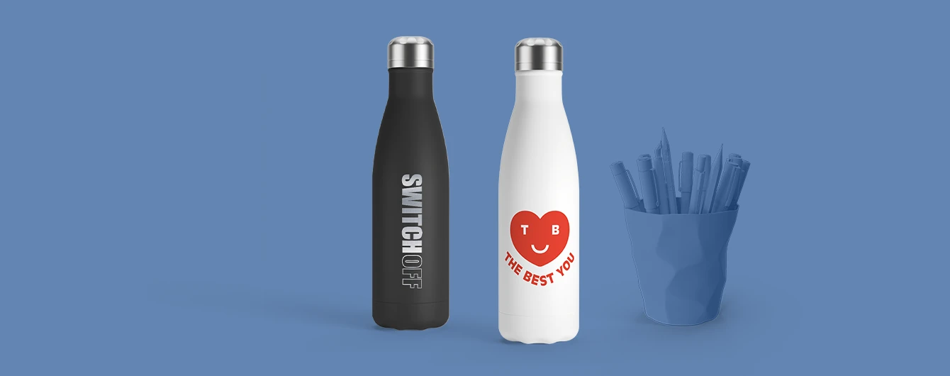 Two branded bottles with metallic caps and a pen pot, arranged on a blue surface with matching backdrop.