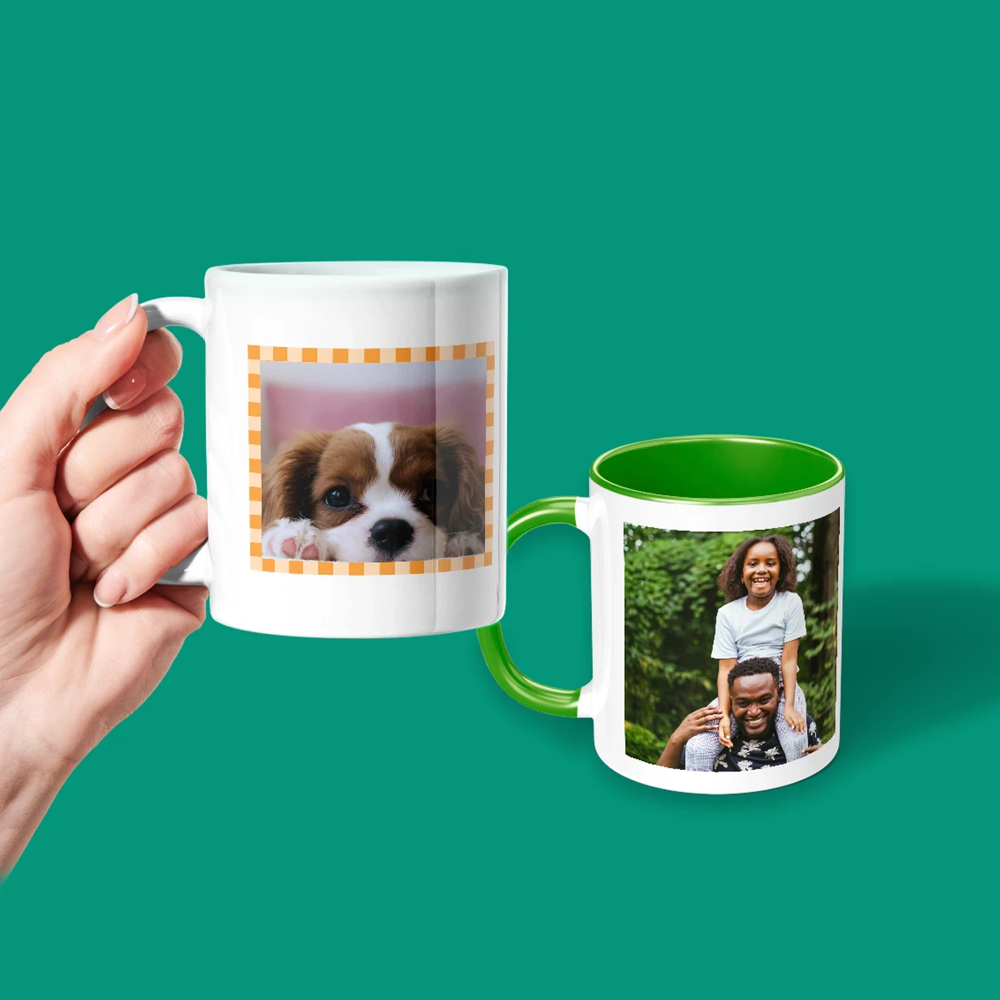 Two ceramic photo mugs on a green background - one held in a hand showing a puppy photo, the other with a green handle and interior showing a man and child smiling outdoors.