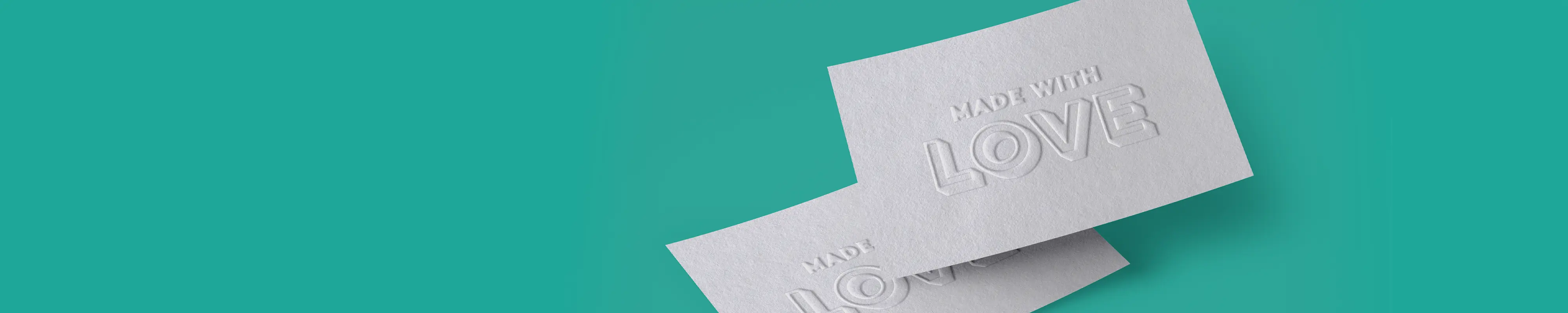 Two white Business Cards with embossed text reading ‘MADE WITH LOVE,’ slightly overlapping on a teal background