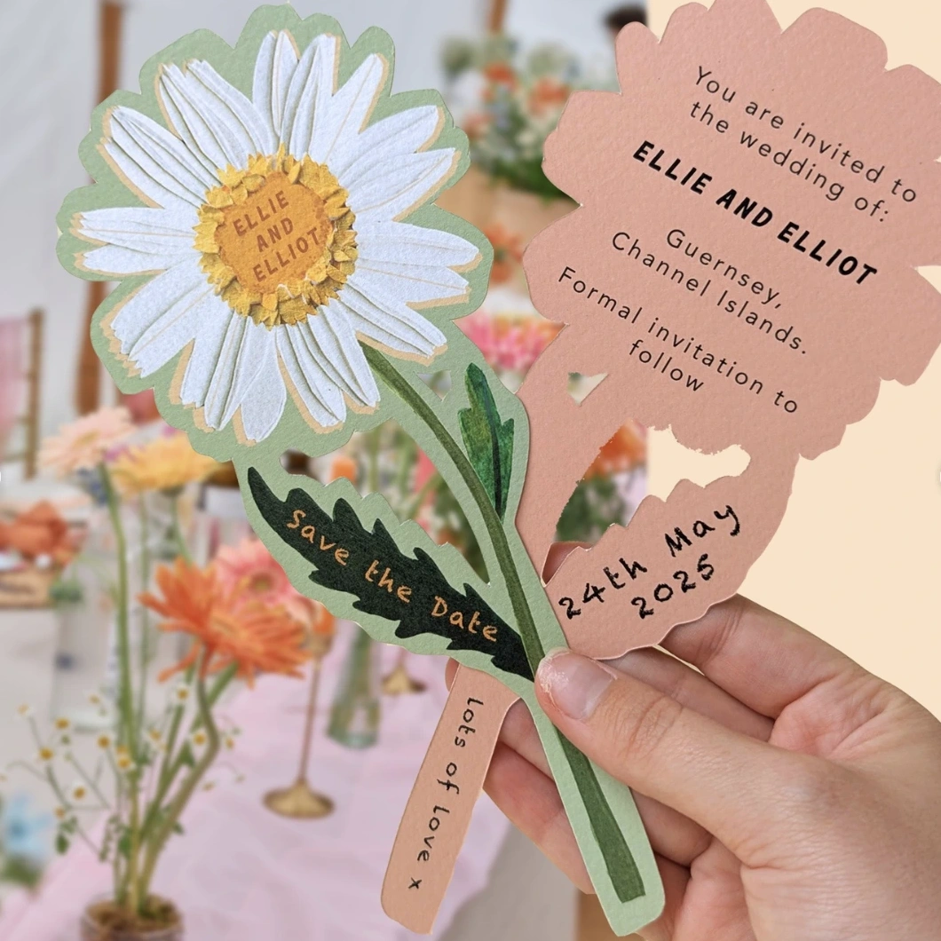Flower-shaped Wedding Invitation, held above a floral table setting.