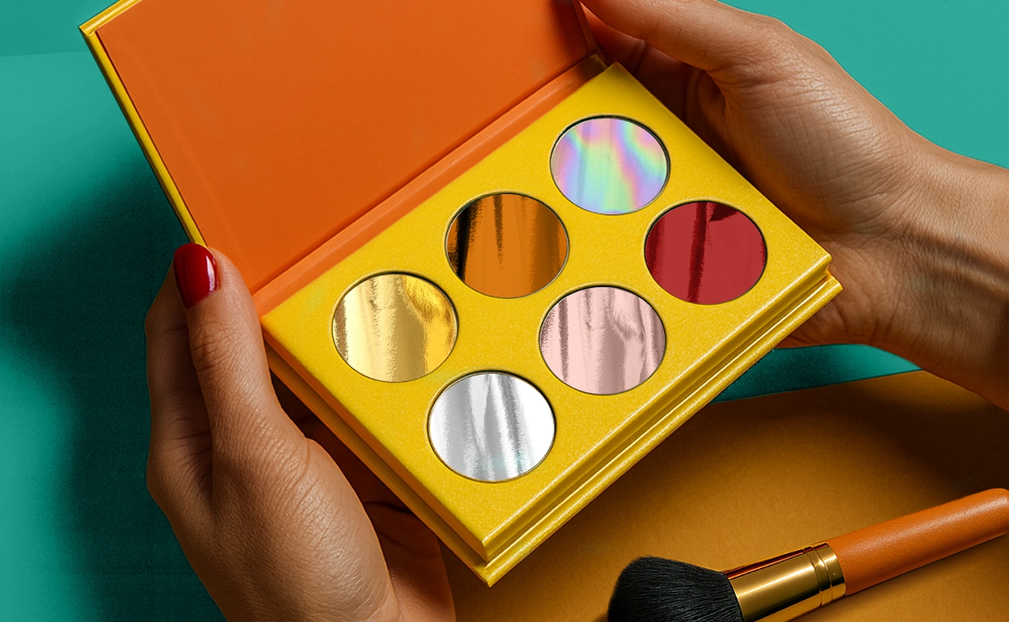 Lady holding a makeup palette with six metallic colours inside, on a blue background.