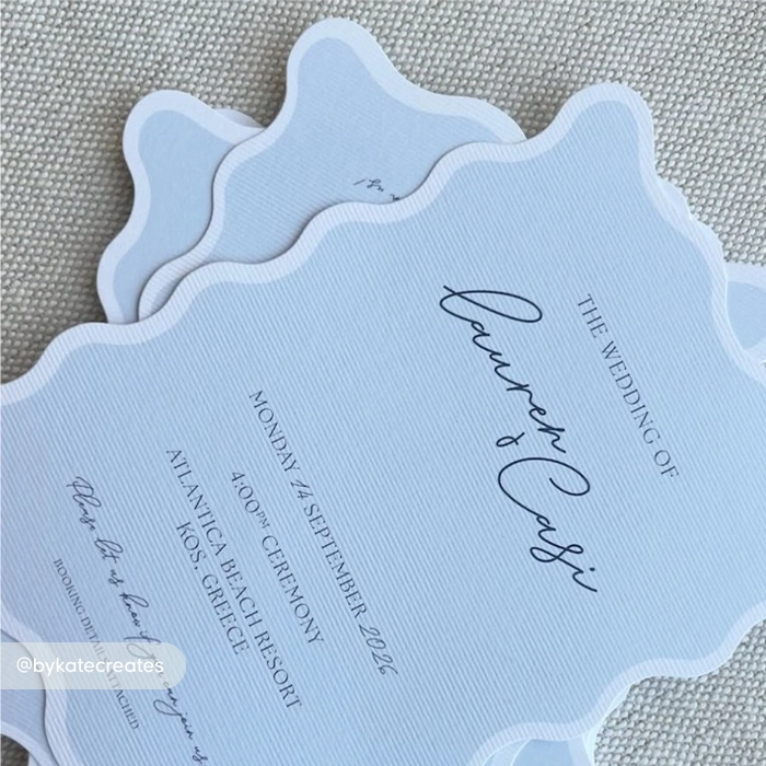 A stack of baby blue Wedding Invitations with a white edge printed on textured cardstock.
