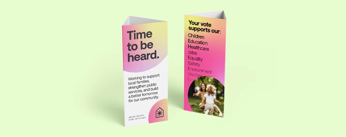 Two triangular, three-sided table talkers displayed on a pale green background, featuring political campaign text such as "Time to be heard" and a list of supported services including education, healthcare, and the environment.
