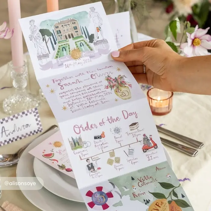 A hand holds a folded Wedding Order of Service featuring watercolour illustrations of a villa and floral details, with the couple’s names, date, and an illustrated timeline of the day’s events