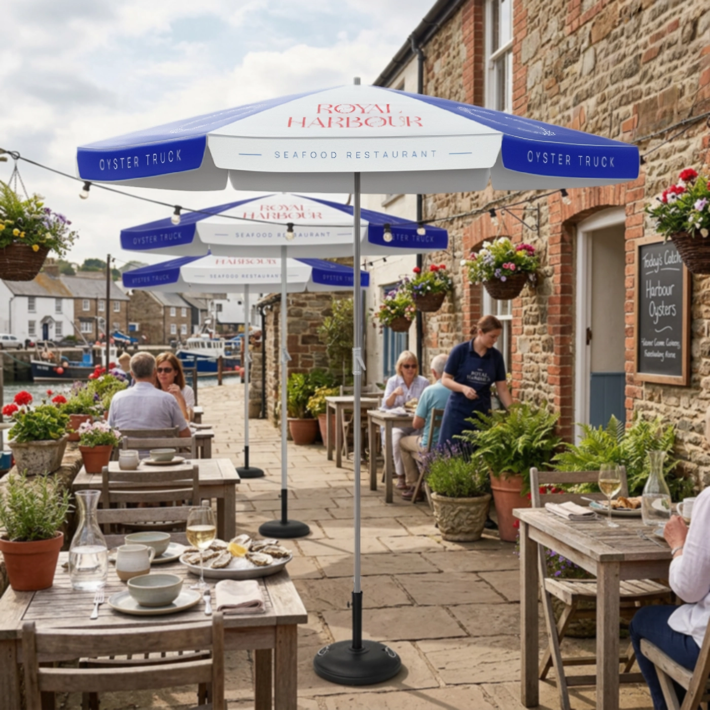 Branded commercial parasols shading outdoor diners at a harbour‑side restaurant.