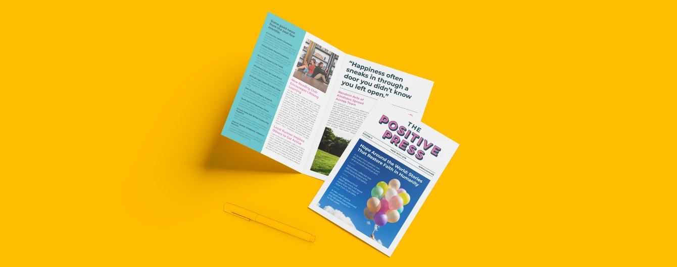 Colourful feel‑good newspaper laid out on a vibrant yellow backdrop.