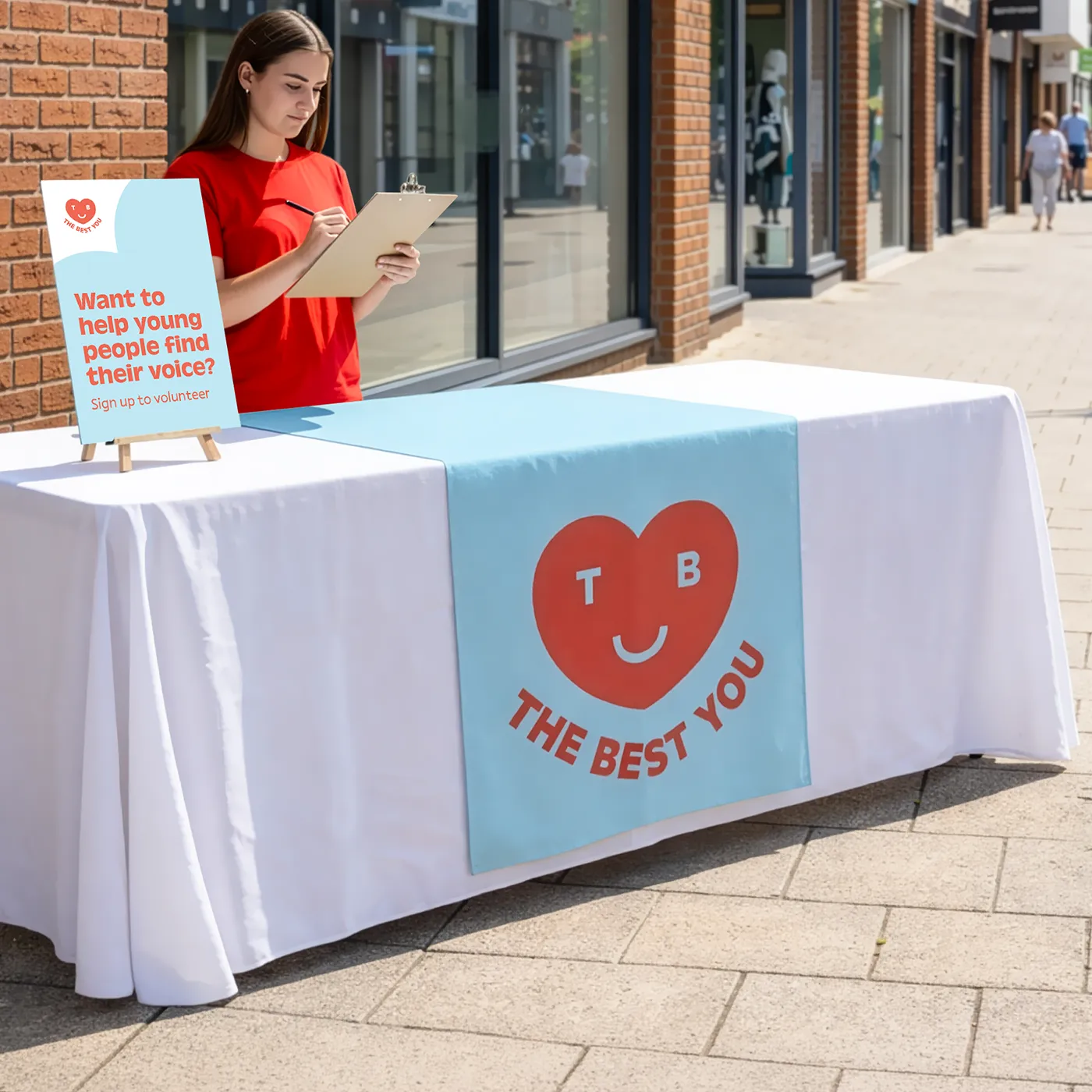 Table runner on a volunteer sign‑up table set up on a city street.