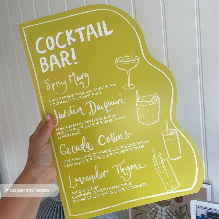 Bespoke shaped wavy-edged lime green cocktail menu featuring white hand-lettered typography and minimalist drink illustrations.