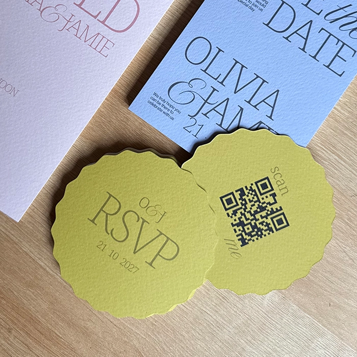 A collection of pastel-coloured wedding stationery, including wavy shaped, lime green RSVP Cards featuring a QR code on one side.