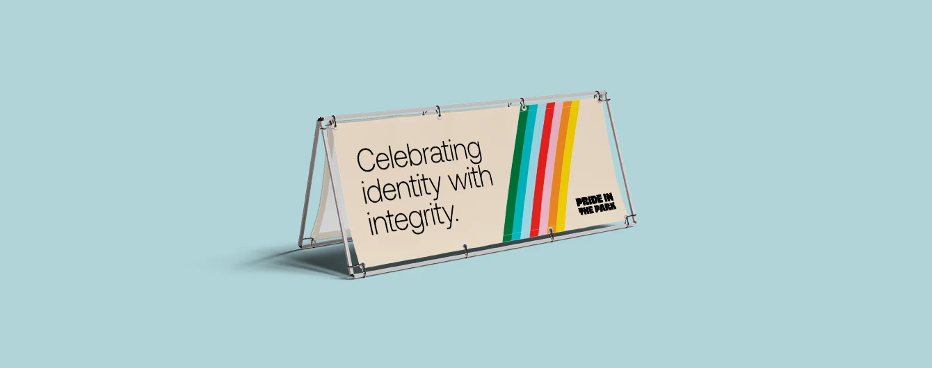 Outdoor a frame banner on a light blue backdrop with a pride‑themed event message.