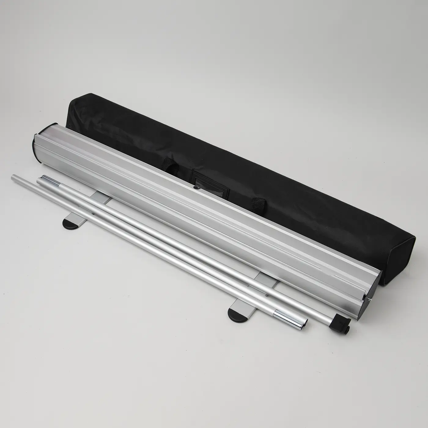 Standard Roller Banner silver hardware featuring a slimline base with two twist-out feet, a three-part bungee support pole, and a black carry bag.