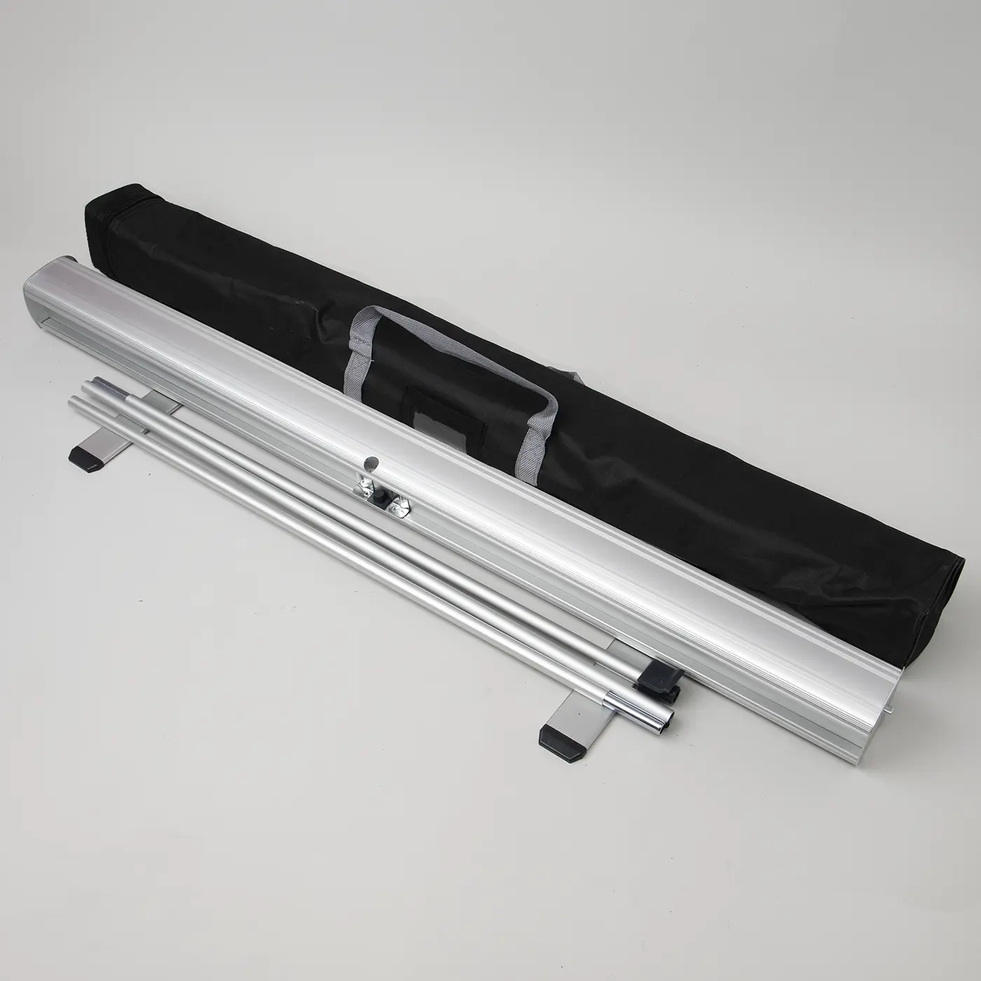 Wide Roller Banner silver hardware set featuring an aluminium base with two swivel feet, a pair of multi-part bungee support poles, and a black carry bag with grey handles.