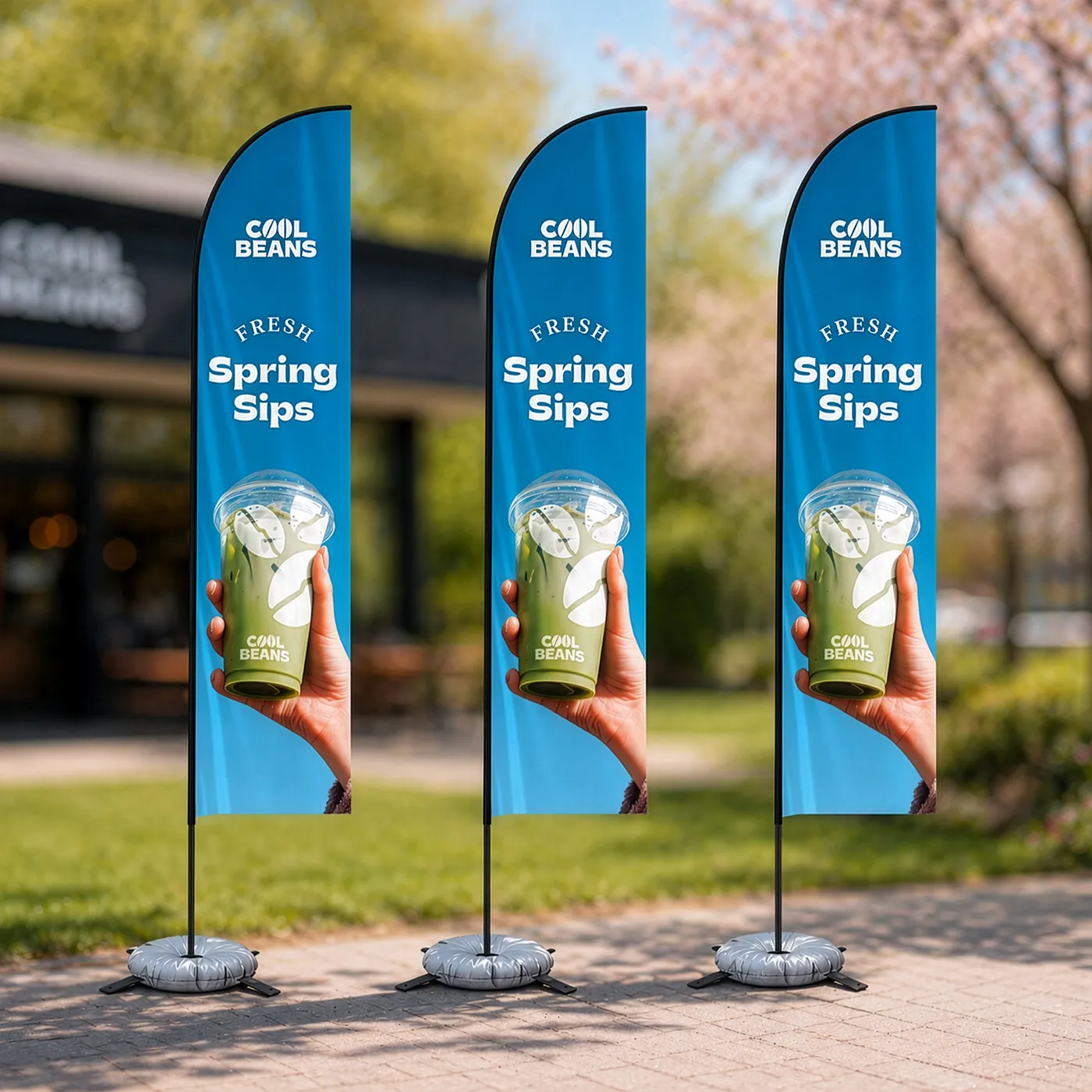 Three outdoor Feather Flags for "Cool Beans", featuring a matcha drink and the text "Fresh Spring Sips."