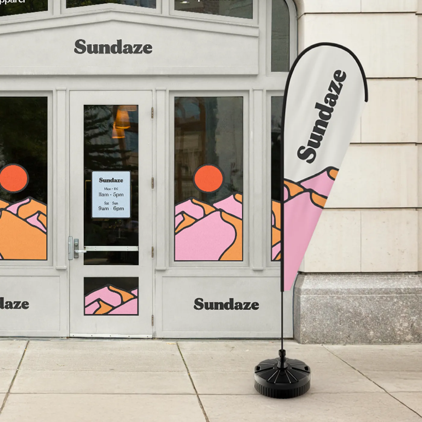 A Teardrop Flag for "Sundaze" featuring a pink and orange mountain design, displayed outside a matching storefront.