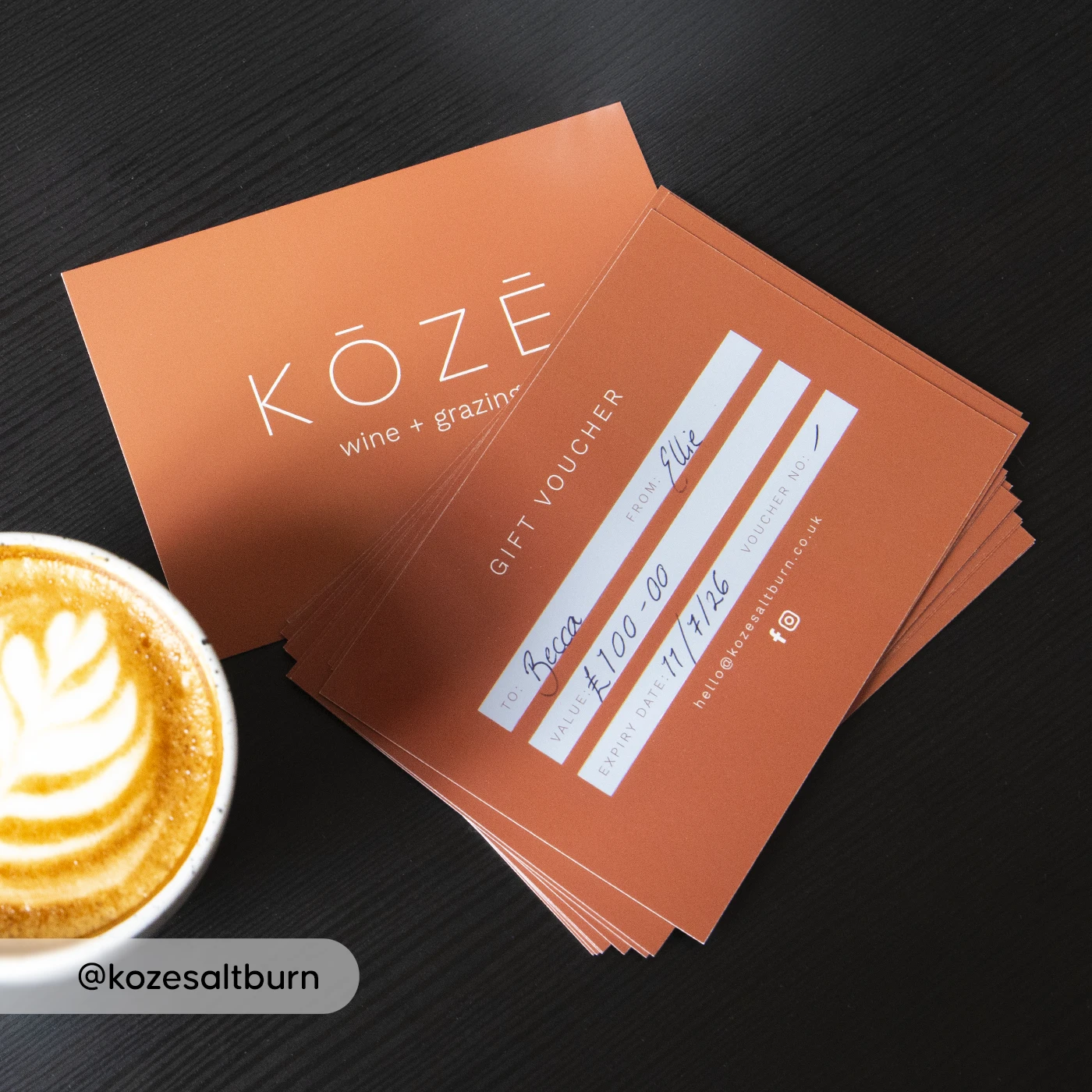 KOZE gift voucher on a table beside a coffee with latte art