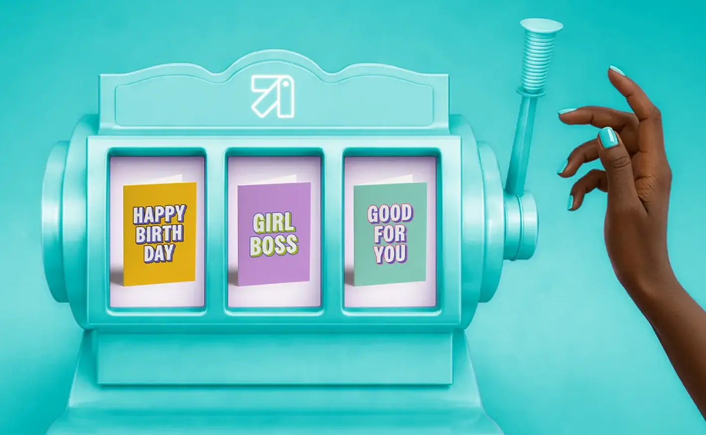A hand reaching out to pull the lever of a teal slot machine displaying three greeting cards that read "Happy Birth Day", "Girl Boss", and "Good For You".