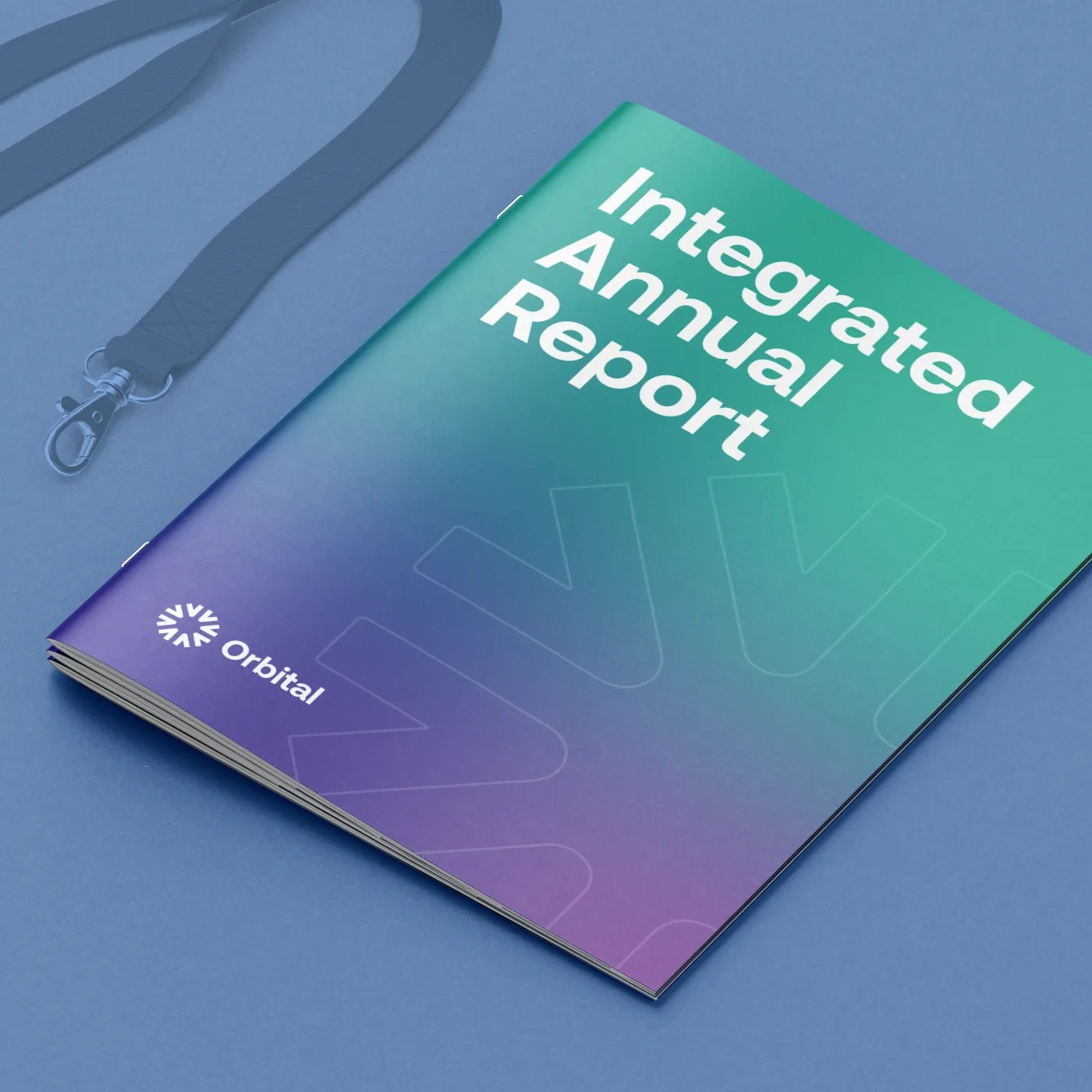 "Integrated Annual Report" Saddle Stitch Booklet next to a lanyard.