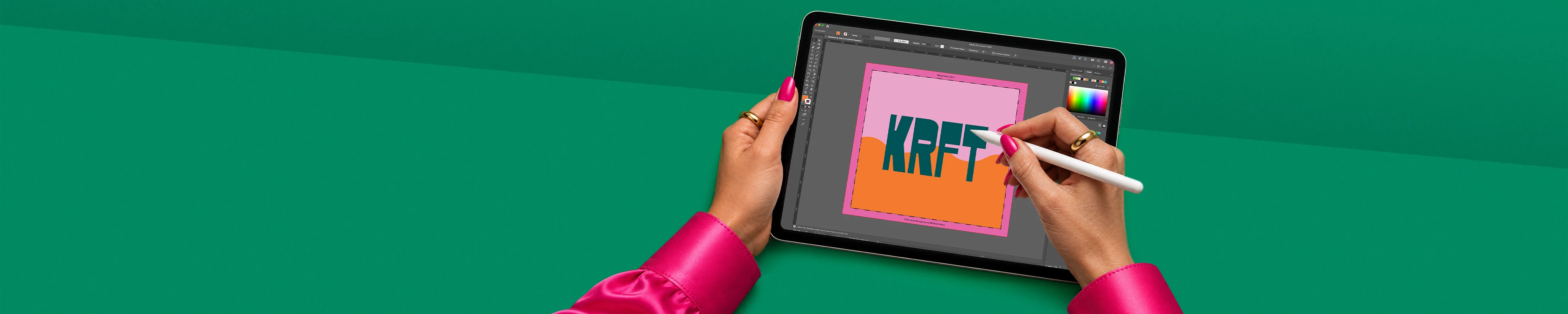 A pair of hands wearing a bright pink long-sleeved top using a stylus to design a artwork featuring the word "KRFT" on a tablet screen, set against a green background.