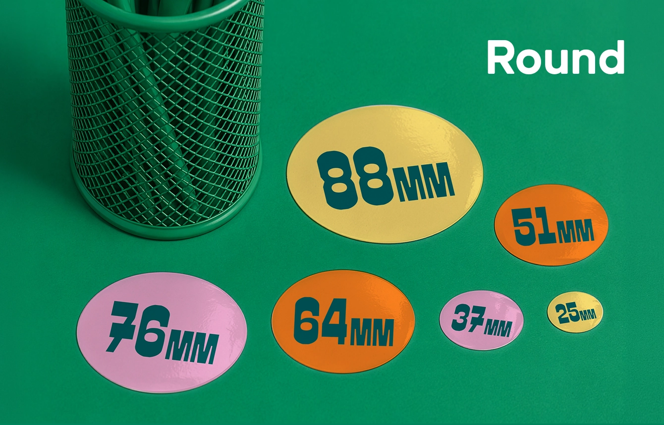 Six round stickers in various colours and sizes ranging from 25 mm to 88 mm, displayed next to a green pencil pot