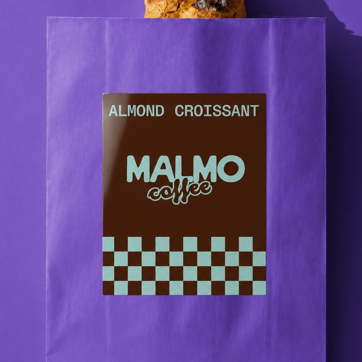 A dark brown rectangular Food Packaging Label for "Malmo Coffee" labelling an "ALMOND CROISSANT".