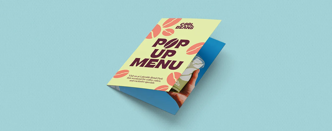 A partially opened folded leaflet for "Cool Beans POP UP MENU" featuring coffee bean graphic details and event location information.