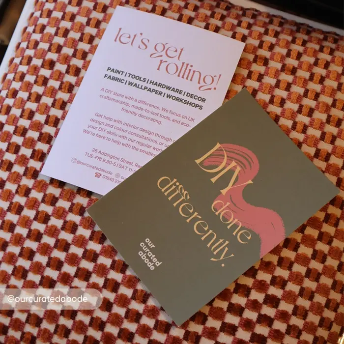 An olive green Flyer reading "DIY done differently." and a white informational Flyer reading "let's get rolling!" on a patterned orange woven fabric.