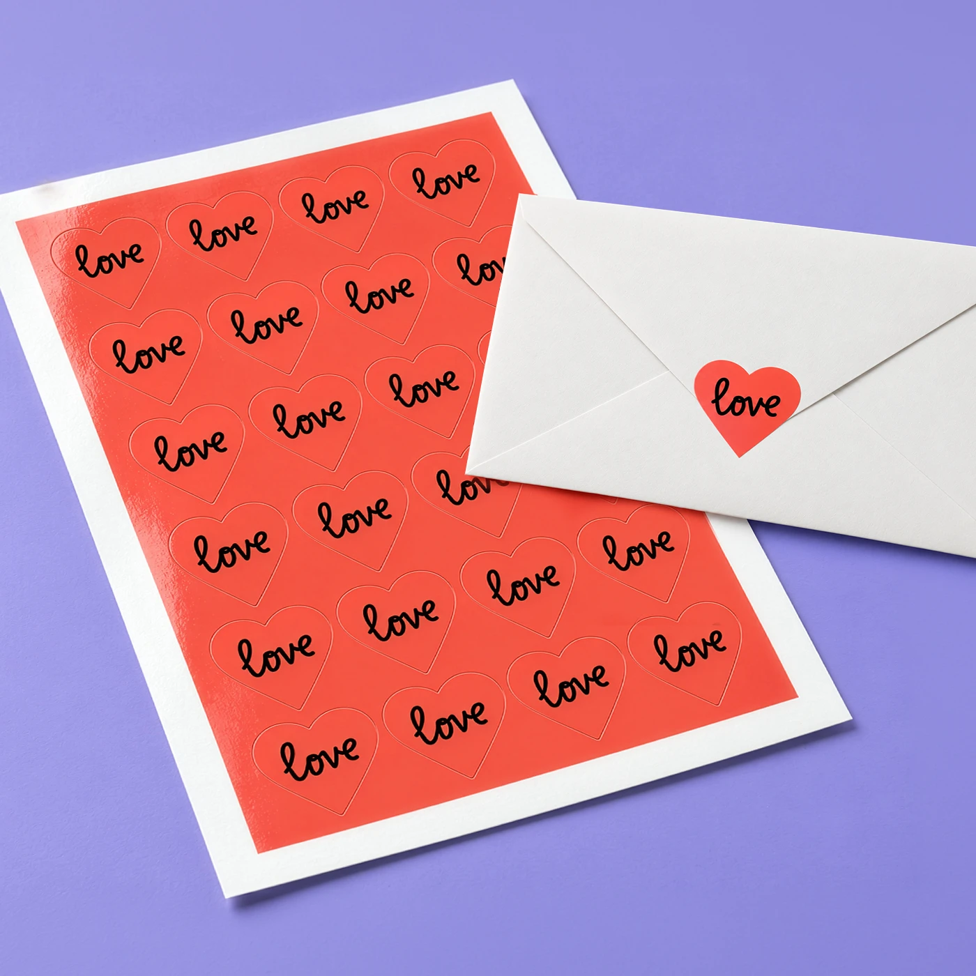 Heart Shaped Sticker Sheet with 'love' text and one Sticker shown sealing an envelope.
