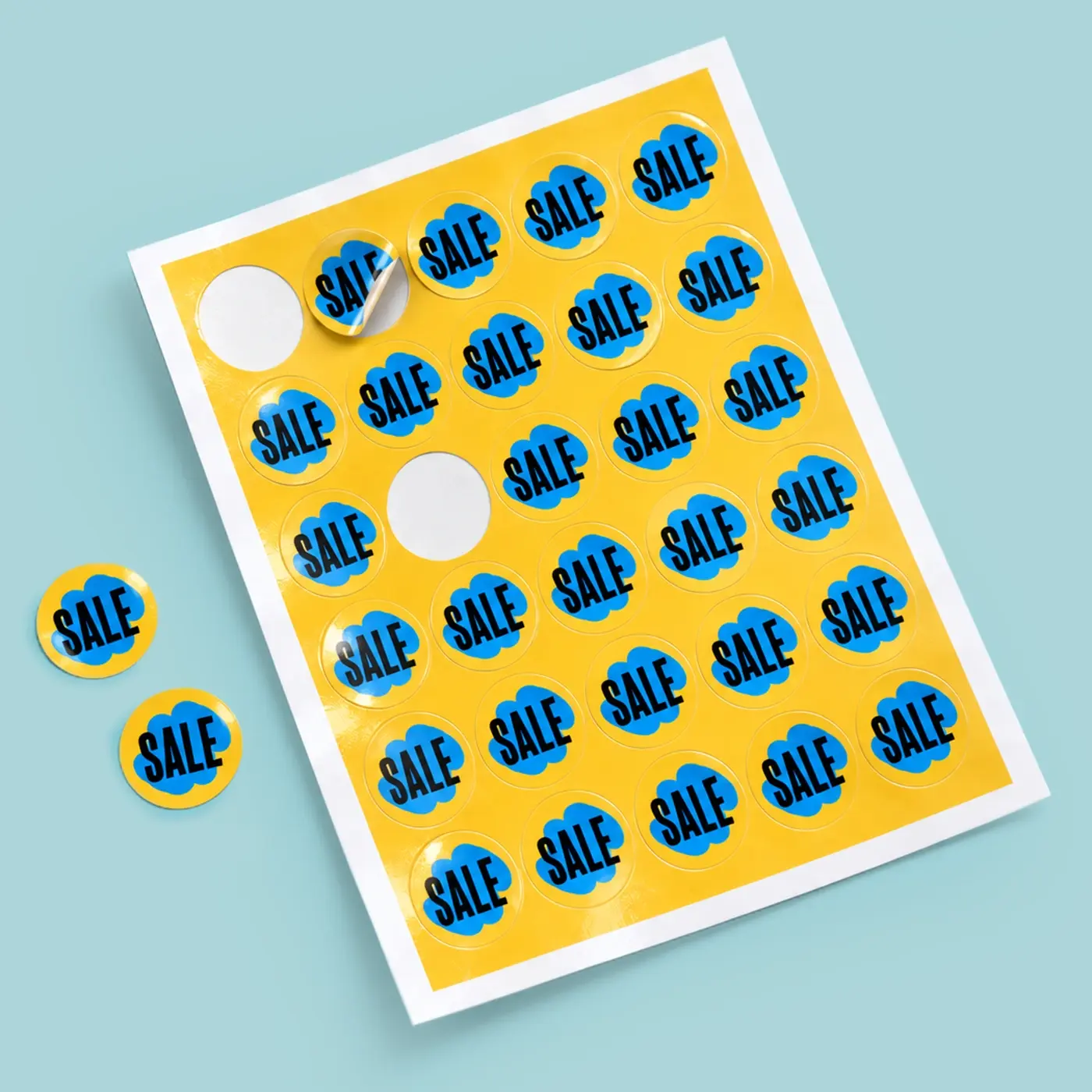 Round sale Sticker Sheet with bold blue and yellow designs, shown alongside individual peel-off Stickers ready for promotions and pricing labels.