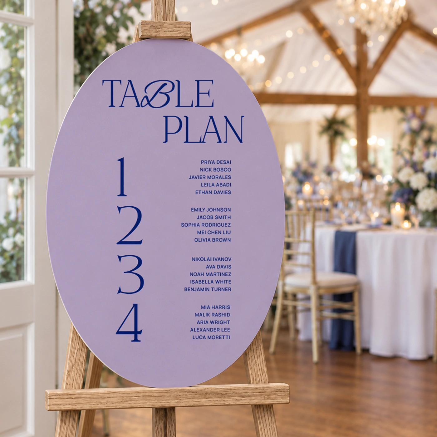 Lilac oval wedding table plan board listing guests for four tables, on a wooden easel in a decorated venue