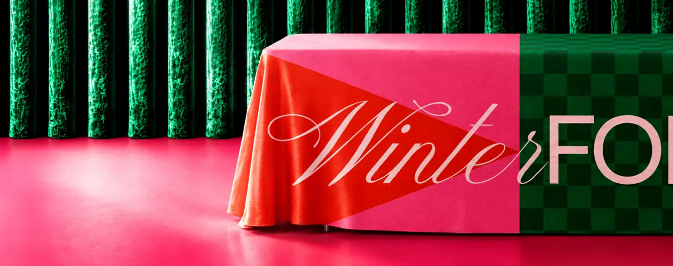Christmas Tablecloth draped over a display table against a festive green backdrop, creating a vibrant seasonal setting.