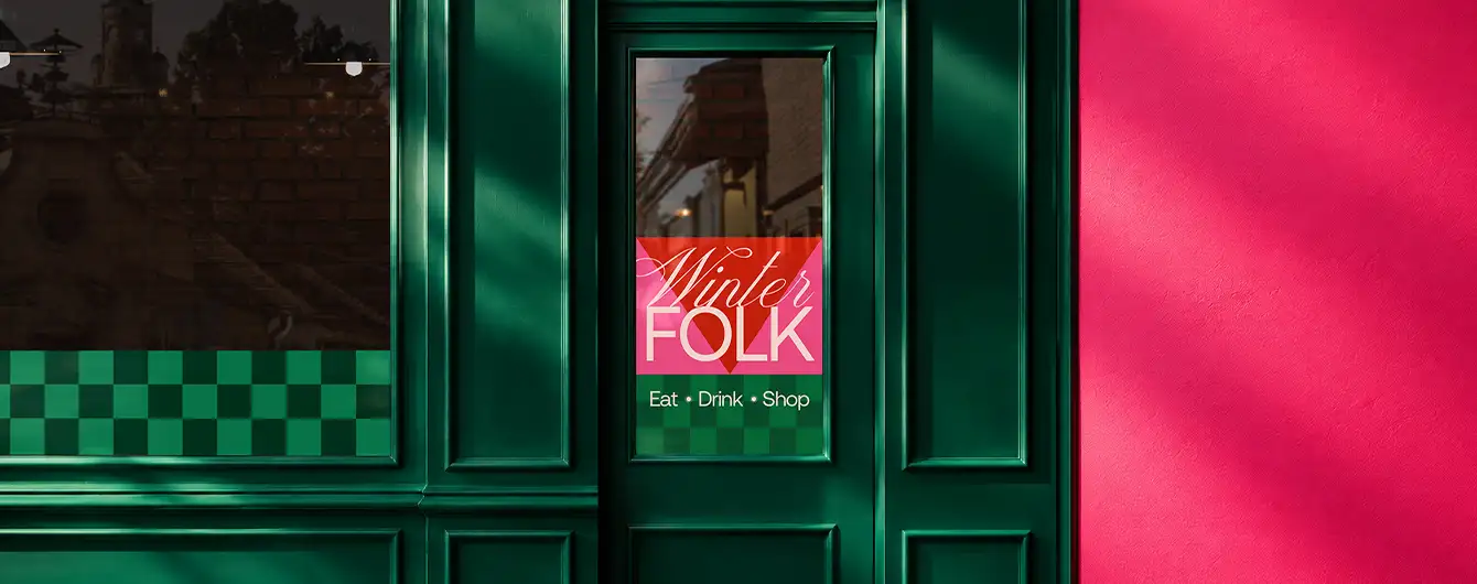 Christmas Window Vinyl applied to a storefront window, featuring a festive design against a vibrant seasonal backdrop.
